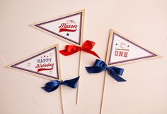 three red, white and blue pinwheels with ribbons on them