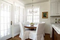 a dining room table with white chairs around it