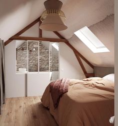 a bed sitting under a window in a bedroom next to a wall mounted air conditioner