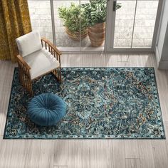 a blue rug with a chair and potted plant in front of a window on top of a hard wood floor