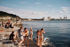 some people are standing on a dock by the water