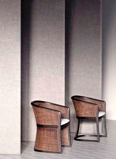 two chairs sitting next to each other in front of a wall