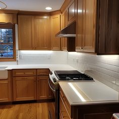 a kitchen with wooden cabinets and white counter tops