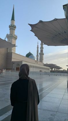 a woman standing in front of a large building