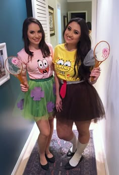 two girls in costumes standing next to each other holding tennis racquets and posing for the camera