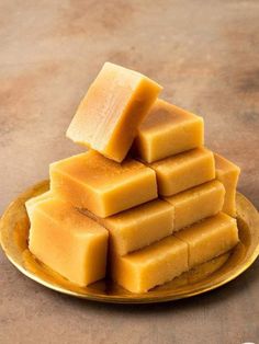 several pieces of yellow soap stacked on top of each other in a gold platter