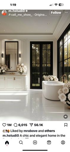 an image of a bathroom with flowers on the counter and tub in the middle, surrounded by windows