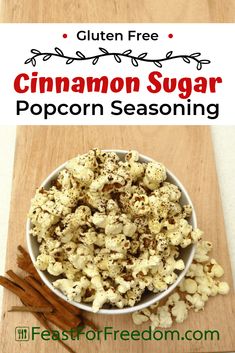 a bowl filled with cinnamon sugar popcorn sitting on top of a wooden cutting board