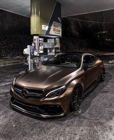 a gold car parked in front of a gas station