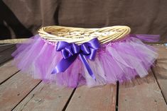 a wicker basket with purple tulle and bow