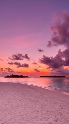 the sun is setting on an empty beach with footprints in the white sand and blue water