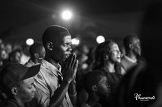 a man standing in front of a group of people with his hands clasped to each other