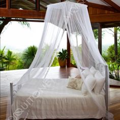 a canopy bed in the middle of a wooden floor