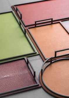 four different colored frames sitting next to each other on top of a table with an open lid