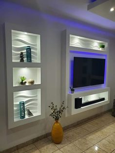 a living room filled with furniture and a flat screen tv mounted on the wall above it