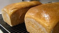 two loaves of bread sitting on top of a cooling rack