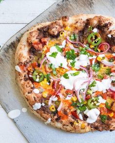 a pizza sitting on top of a pan covered in cheese and veggie toppings