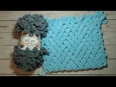 a blue knitted blanket sitting on top of a wooden floor next to a bottle of beer