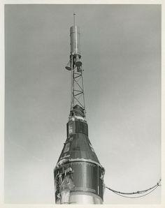 a black and white photo of a very tall building with a radio tower on top