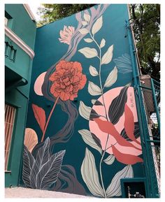 a mural on the side of a building with flowers and leaves painted all over it