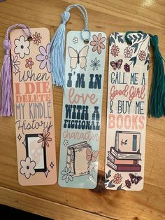 three bookmarks with words and pictures on them sitting on a table next to each other