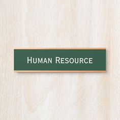 a green sign that says human resources on the side of a wooden wall with white lettering