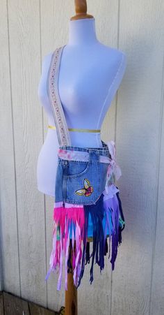 a mannequin wearing a jean skirt with multicolored fringes on it