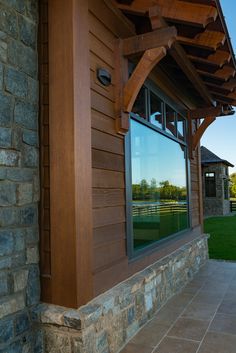 an outside view of a house with a stone wall and wood trim around the windows