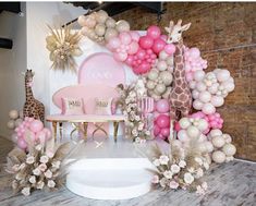 a pink and gold baby shower with giraffes, balloons, chairs and decorations