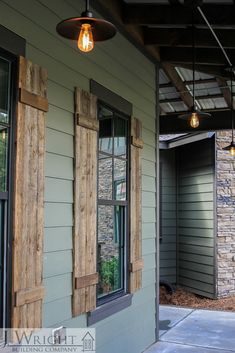 an outside view of a house with wooden shutters and windows that have light bulbs hanging from them