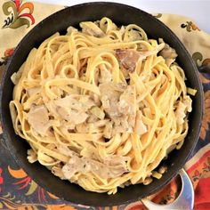 a bowl filled with pasta and meat on top of a table