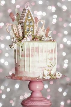 a cake with white frosting and candy canes on top is sitting on a pink pedestal