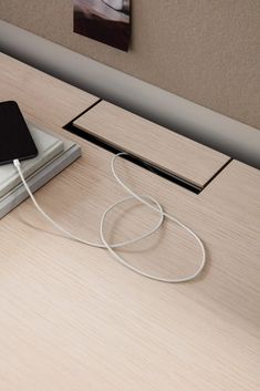 an electronic device is plugged into a charger on a table with a book