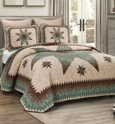 a bed covered in a green and brown quilted comforter with stars on it