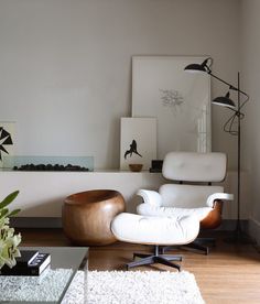 a living room filled with furniture and a white rug on top of a hard wood floor