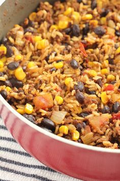 a red pan filled with mexican rice and beans