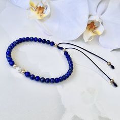 ✭ Embrace the beauty and positive energy of Lapis Lazuli with this beautiful bracelet that is crafted with genuine natural lapis lazuli stones and featuring gold-filled or 14k solid gold accent beads as your choice. The center piece is decorated with a white freshwater pearl adding even more elegance to the bracelet. The adjustable navy blue cord ensure a comfortable and personalized fit, and bracelet is custom-made to your own wrist size - read bellow my "wrist size guide" to find the perfect f Lapis Lazuli Bracelet, Lapis Lazuli Jewelry, Power Stone, Lapis Lazuli Stone, Bracelet Ideas, White Freshwater Pearl, Beaded Keychains, Gold Accent, Blue Bracelet