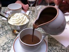 a person pouring chocolate into a cup