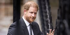 a man in a suit and tie is holding his hand out