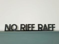 a metal sign that says no rice raff on top of a shelf in front of a white wall