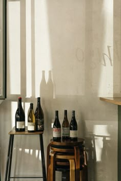 several bottles of wine are sitting on stools