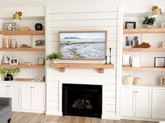 a living room filled with furniture and a fire place in front of a white wall