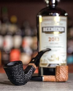 a pipe sitting on top of a counter next to a bottle