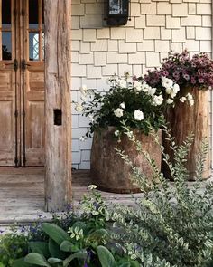 an instagram with two large wooden planters on the front porch and flowers in them