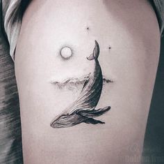 a woman's thigh with a whale tattoo on it