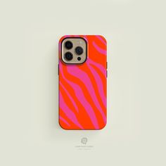 an orange and pink phone case sitting on top of a white surface with zebra print