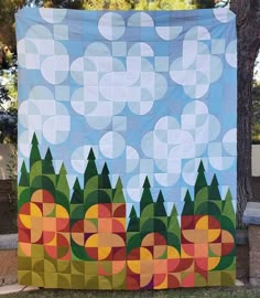 a large quilt hanging on the side of a tree