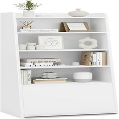 a white book shelf filled with books next to a plant on top of a table