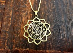 the flower of life pendant is shown on a wooden surface