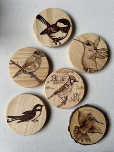 four wooden coasters with birds on them